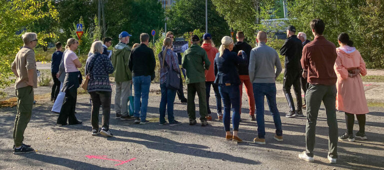 Ryhmä ihmisiä kävelyllä ja tutustumassa alueeseen